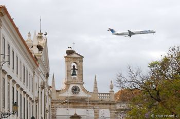 Bociany i samoloty nad dachami Faro, Algarve, Portugalia